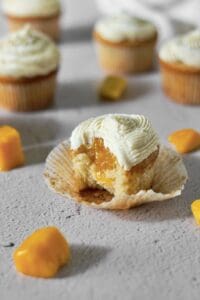 mango cupcake, missing a bite, and showing the filling inside