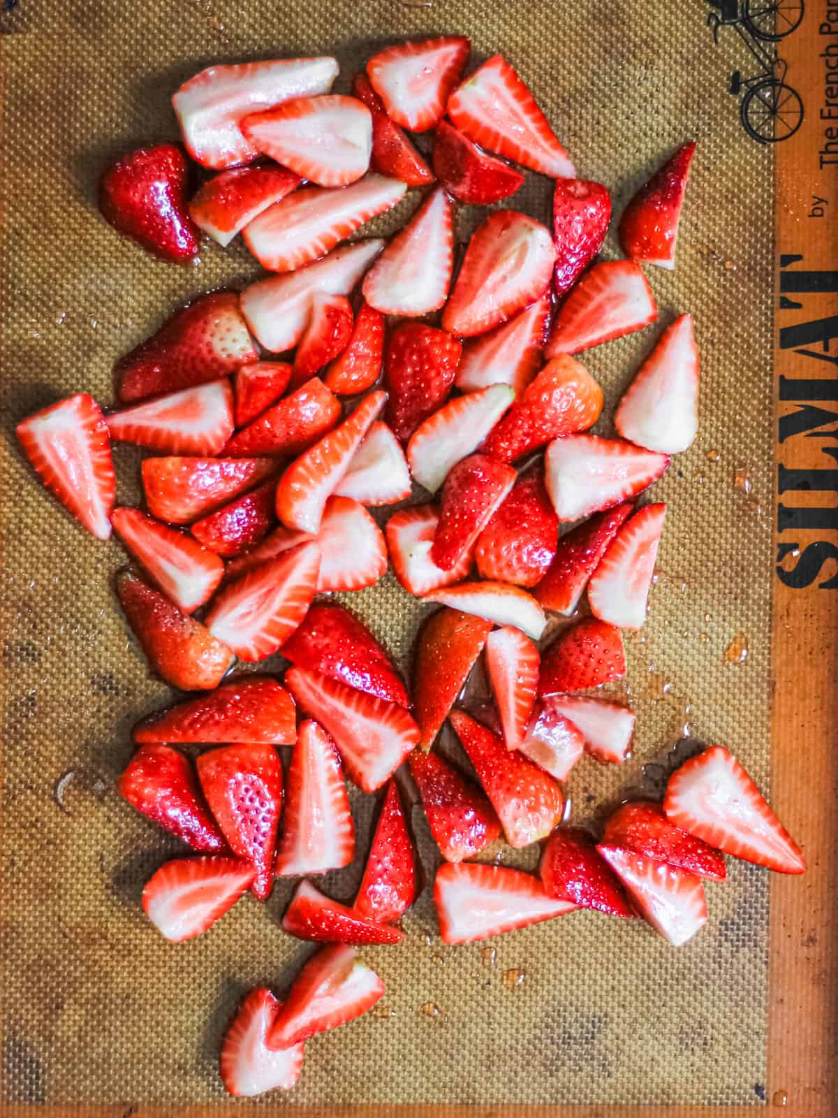 Up-close image of chopped strawberries on a baking sheet.