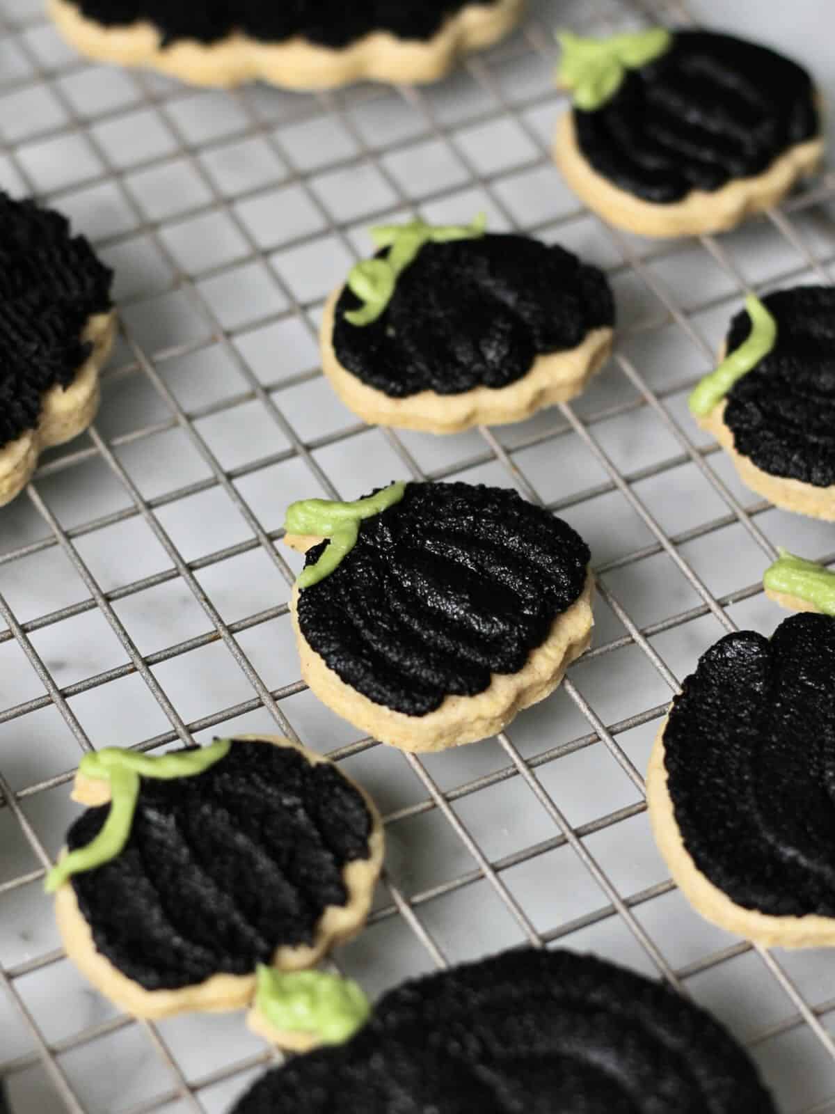 Black pumpkin cookies, decorated with a black cocoa frosting.