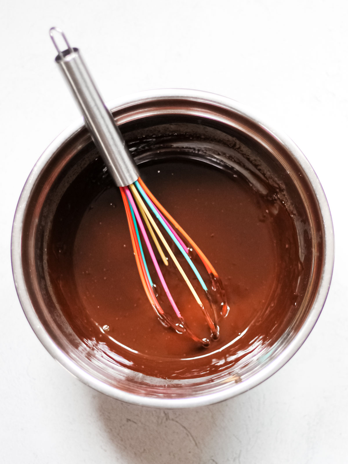 Whisk in a metal bowl full of melted chocolate and heavy whipping cream.