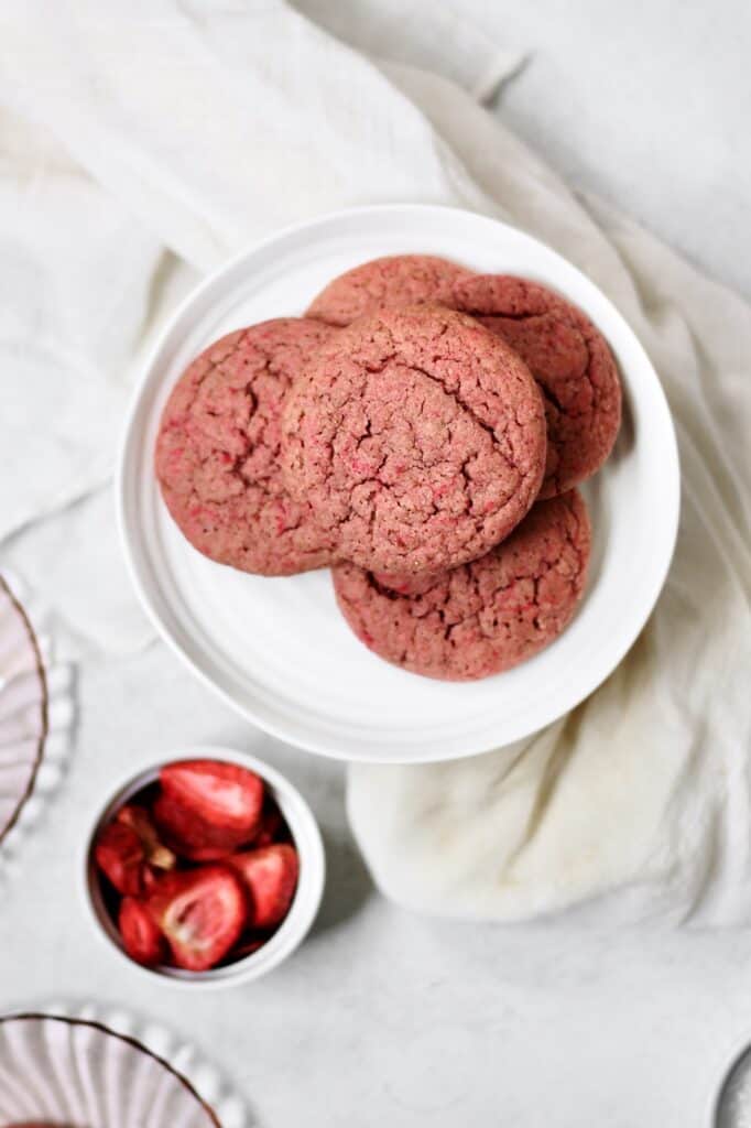 overhead image of cookies made with freeze dried strawberry powder, sitting on a white small cake stand