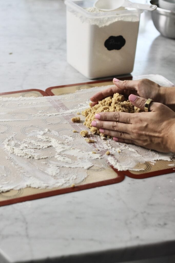 forming balls of dough on floured silicon baking mats