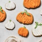 fully decorated pumpkin cookies, coated in orange and white buttercream