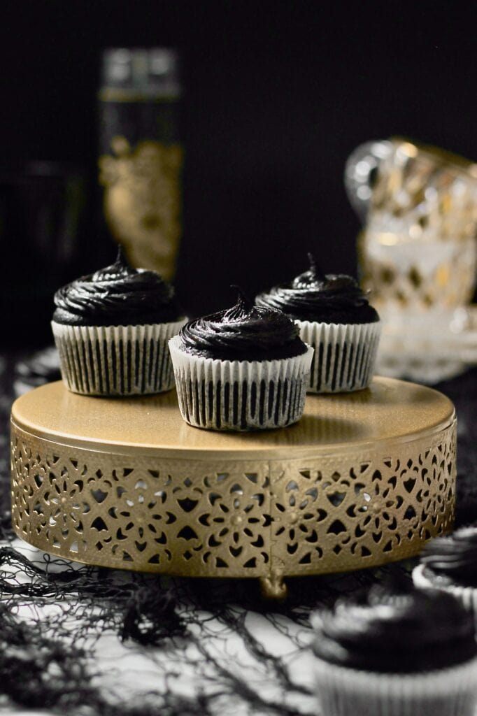 black cocoa cupcakes, sitting on a gold cake stand