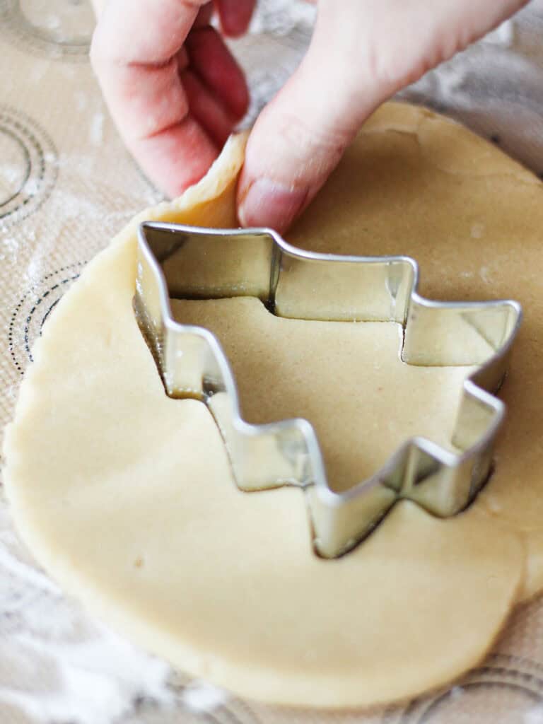 Process shot for cutting dough for Christmas tree sugar cookies.