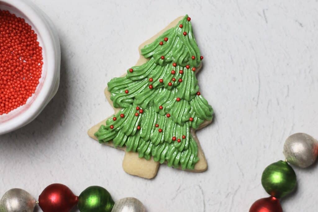 one of many Christmas tree sugar cookies, decorated with sprinkles and green buttercream