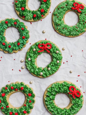 Christmas wreath cookies, decorated in a green buttercream with some red frosting for bows and accents.