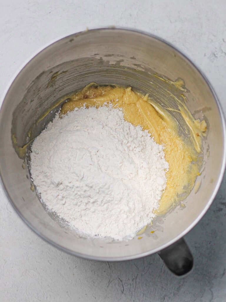 Dry ingredients in bowl of cookie dough, along with wet ingredients.