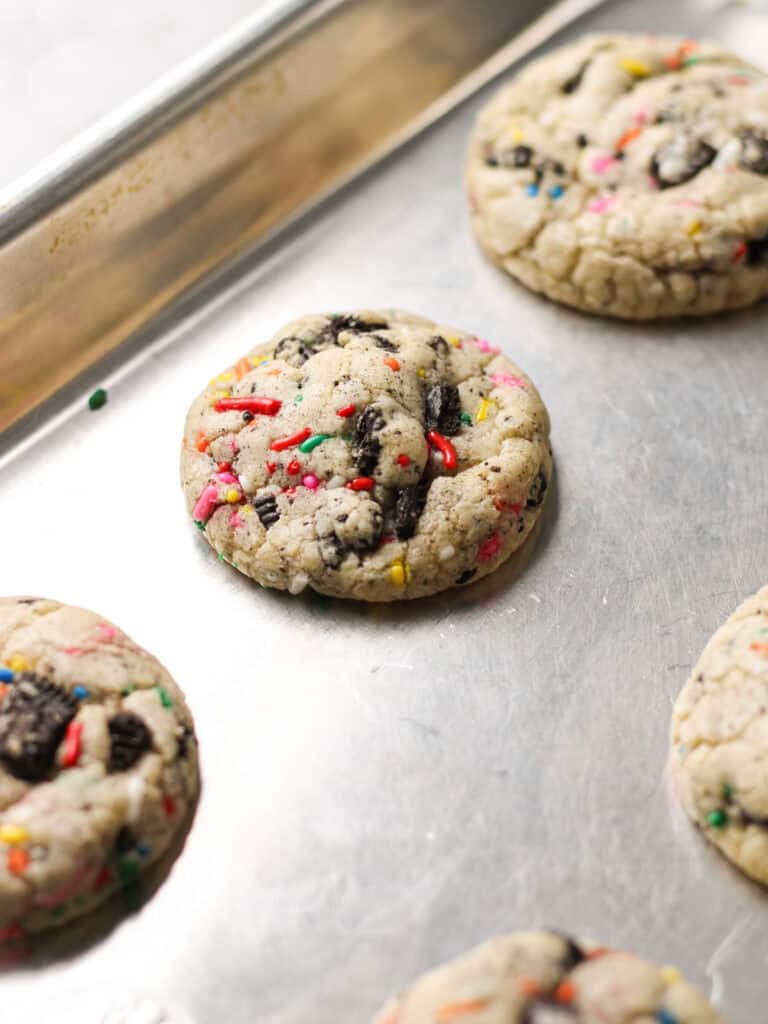 Baked Oreo funfetti cookies, sitting on a baking sheet.