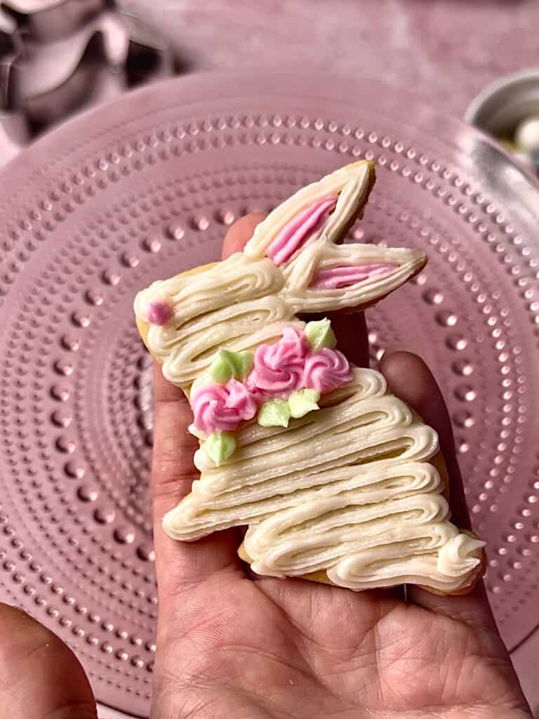 decorated white bunny cookie on a pink background