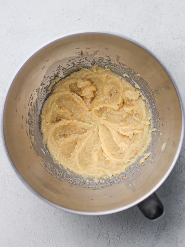 Mixing bowl full of light colored cookie dough.