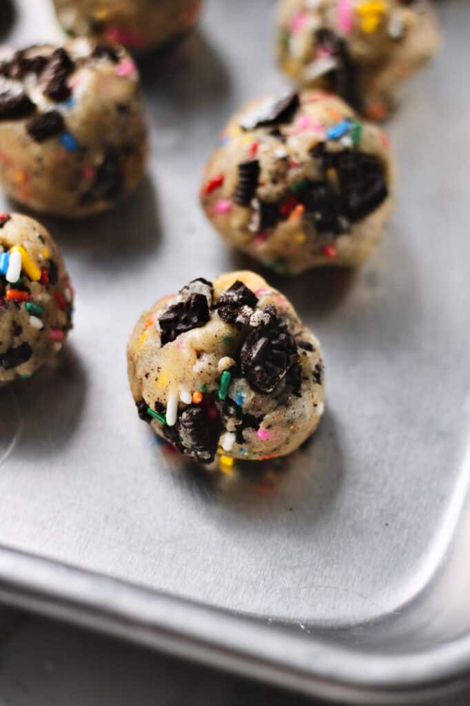 Oreo funfetti cookie dough balls sitting on a baking sheet
