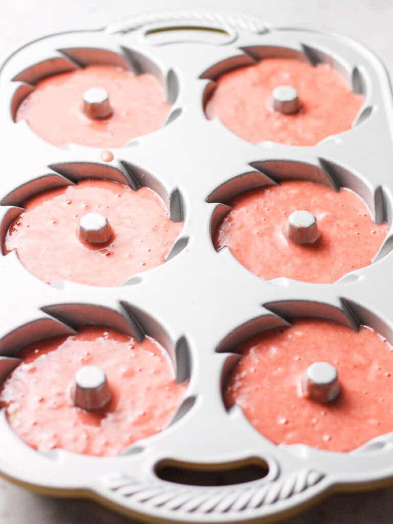 Bundt cake pan with six cavities for mini Bundts, full of strawberry cake batter.