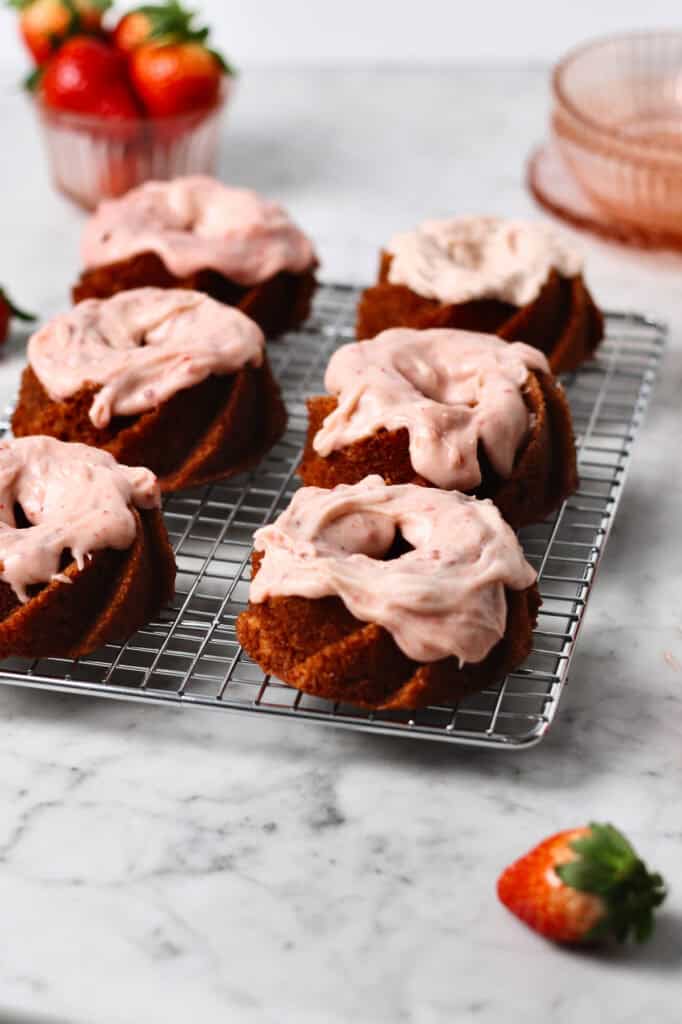 strawberry cream cheese glaze on top of six mini bundt cakes.