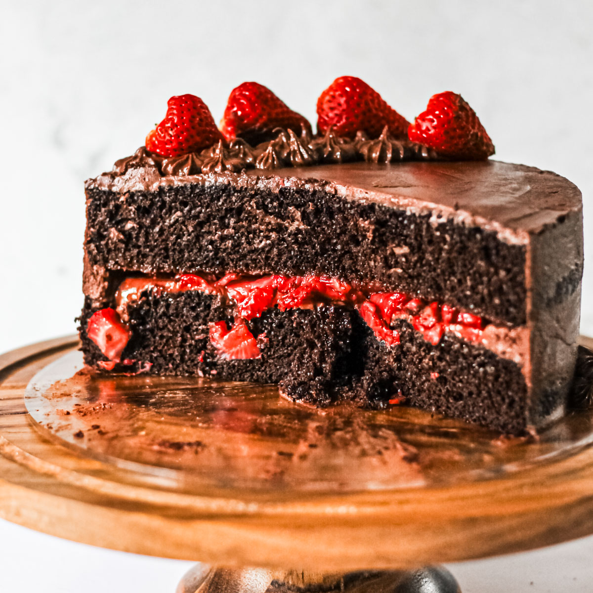 Inside look at chocolate layer cake with strawberry filling.