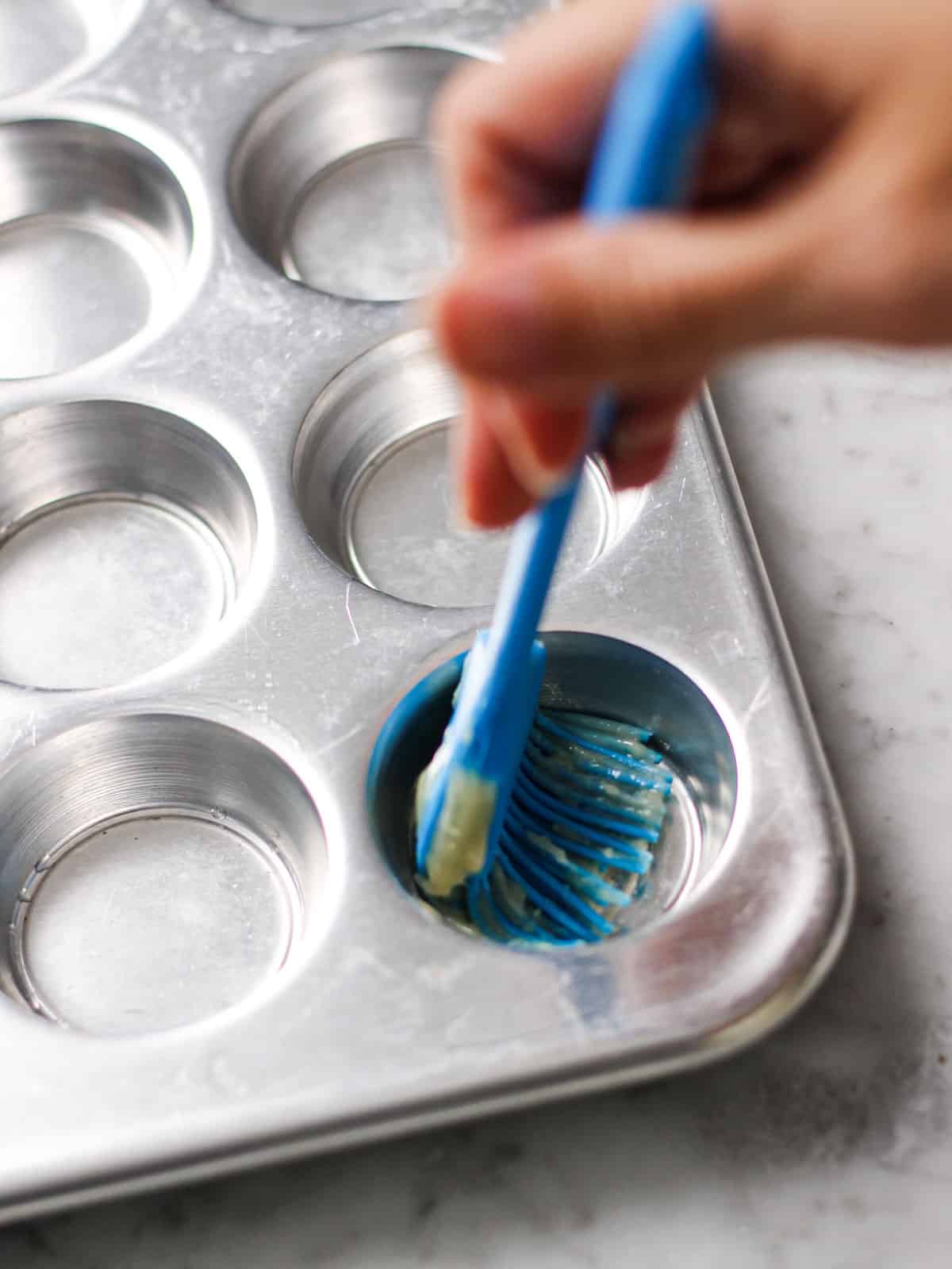 Greasing pan for mini muffins with a silicon pastry brush.