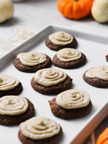 Mascarpone cookies, sitting on a white platter surrounded by small orange and white pumpkins.