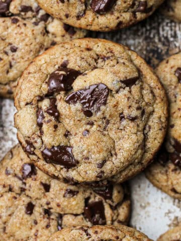 Hero shot of baked big batch chocolate chip cookies, sitting on a cookie sheet.