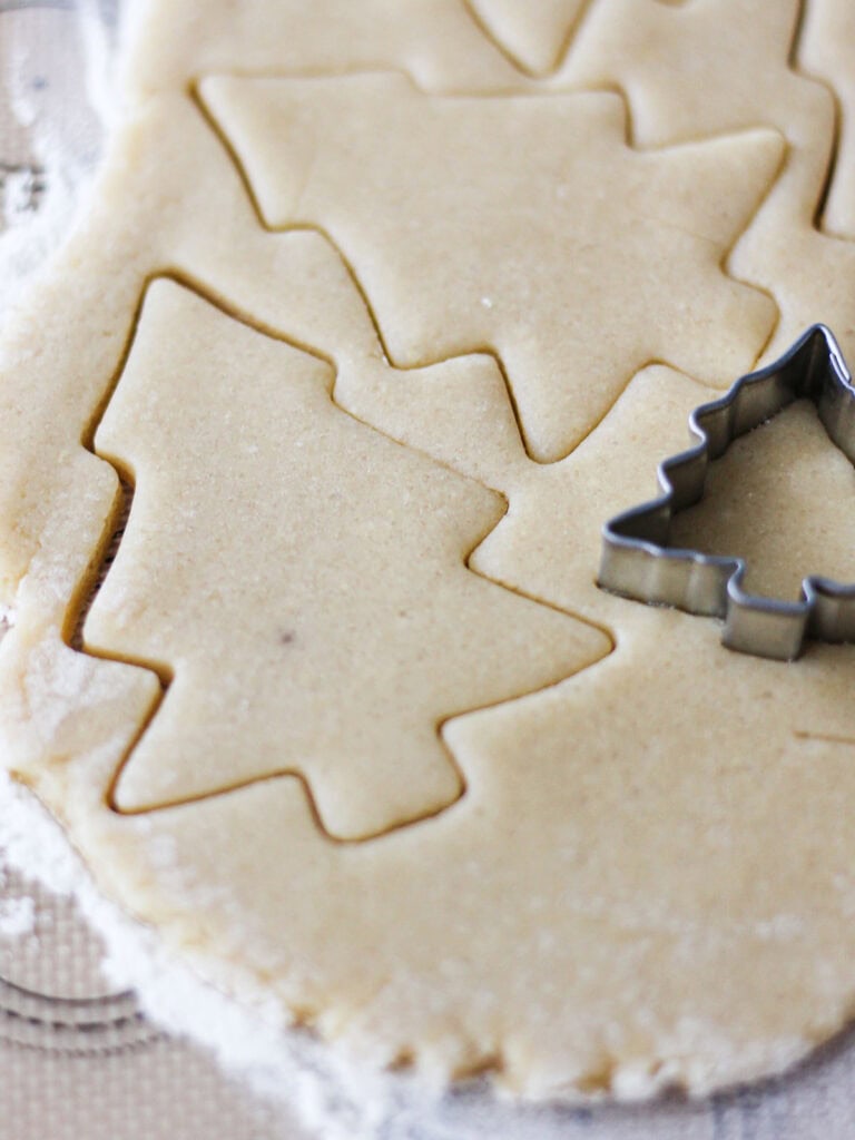 Process shot for cutting dough for Christmas tree sugar cookies.
