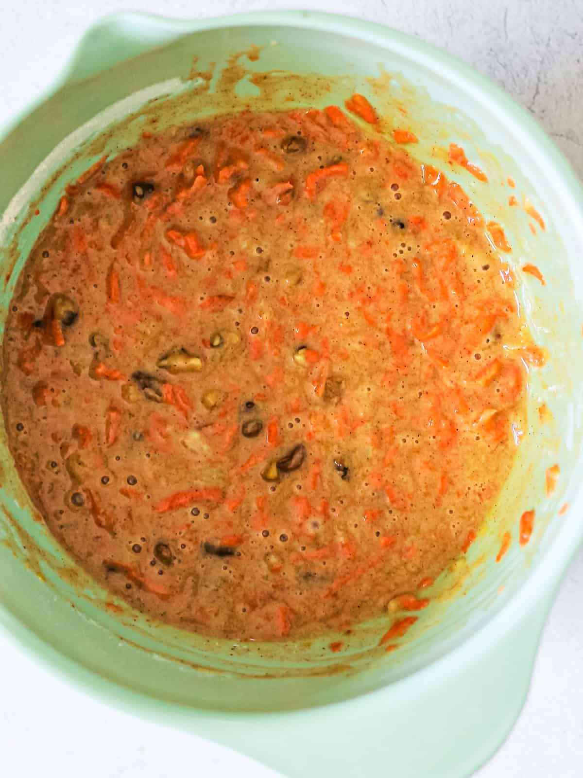 Image of shredded carrots and nuts, mixed into the batter for carrot cake.
