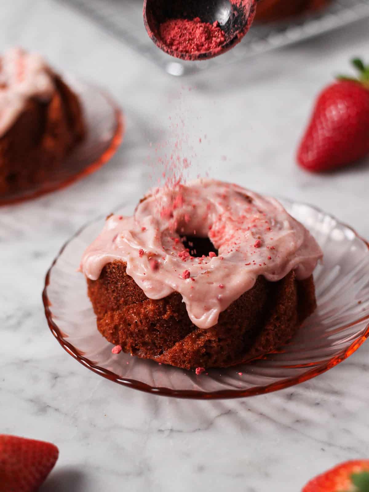 Adding freeze dried strawberry powder to the tops of mini strawberry Bundt cakes.