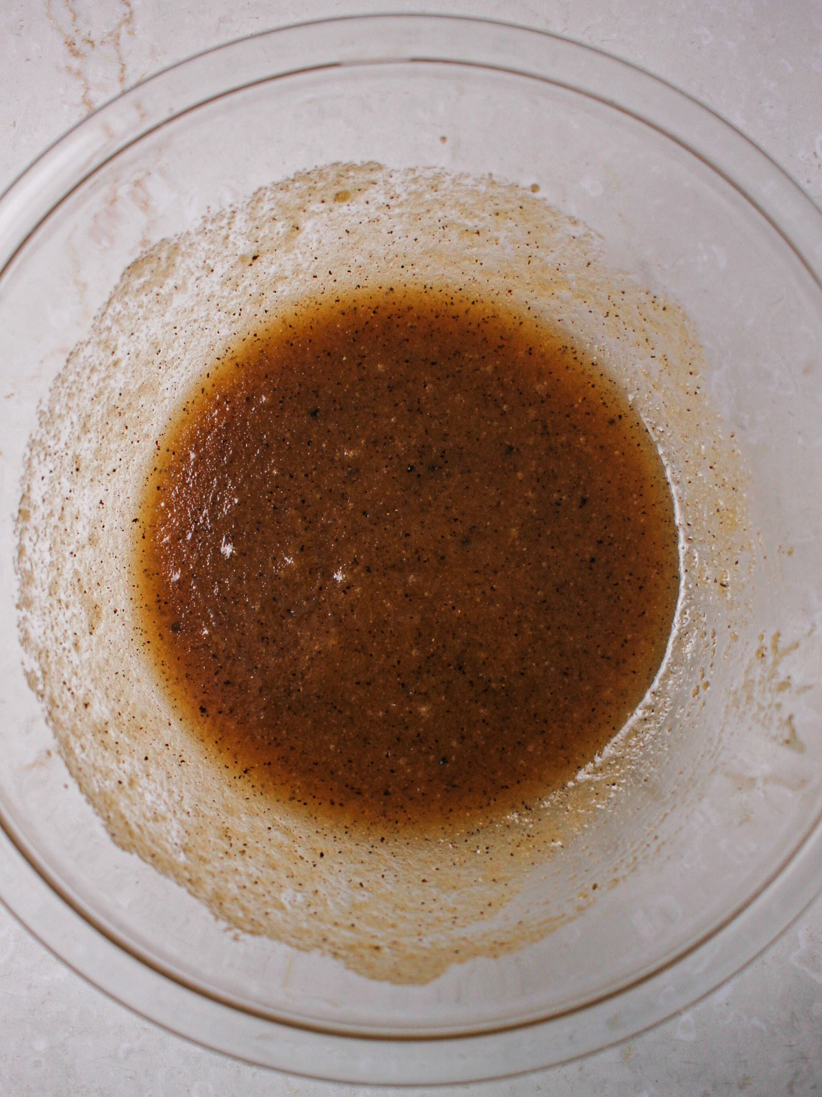 Beginning of making cookie dough, with brown butter and sugars mixed together in a bowl.