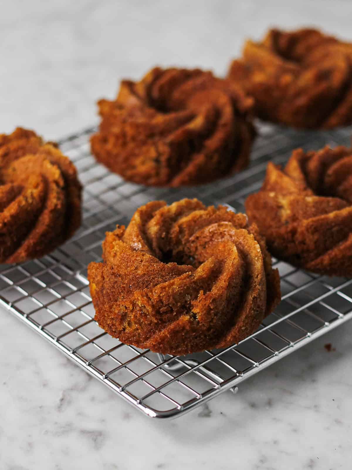 Mini carrot bundt cakes on a cooling rack.