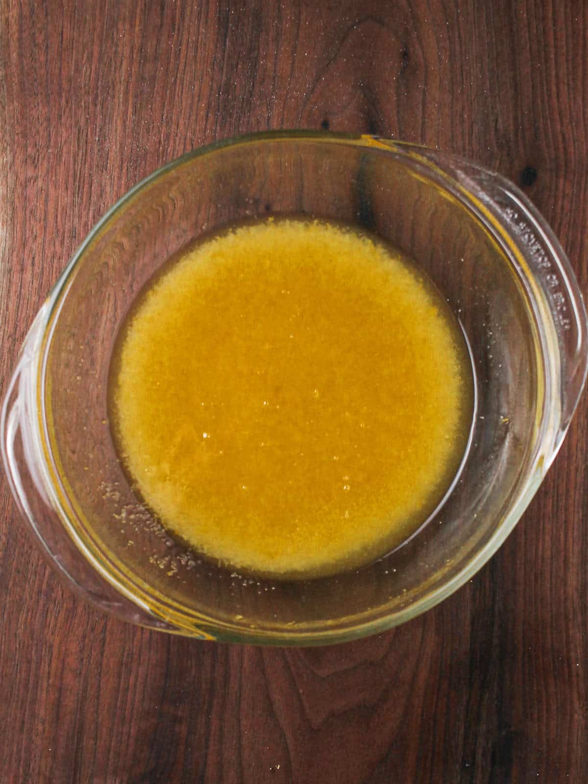 Bowl of wet ingredients on a wooden background.