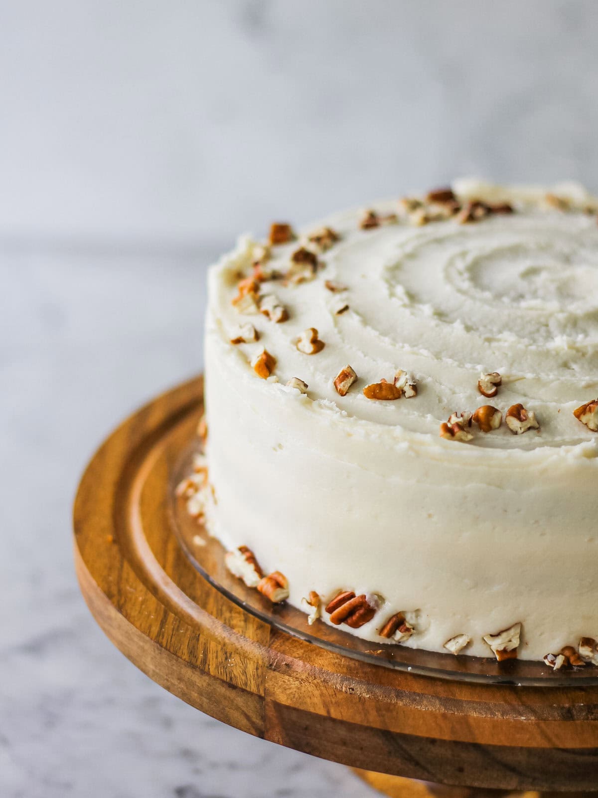 Old fashioned carrot cake, frosted with cream cheese and decorated with pecans.
