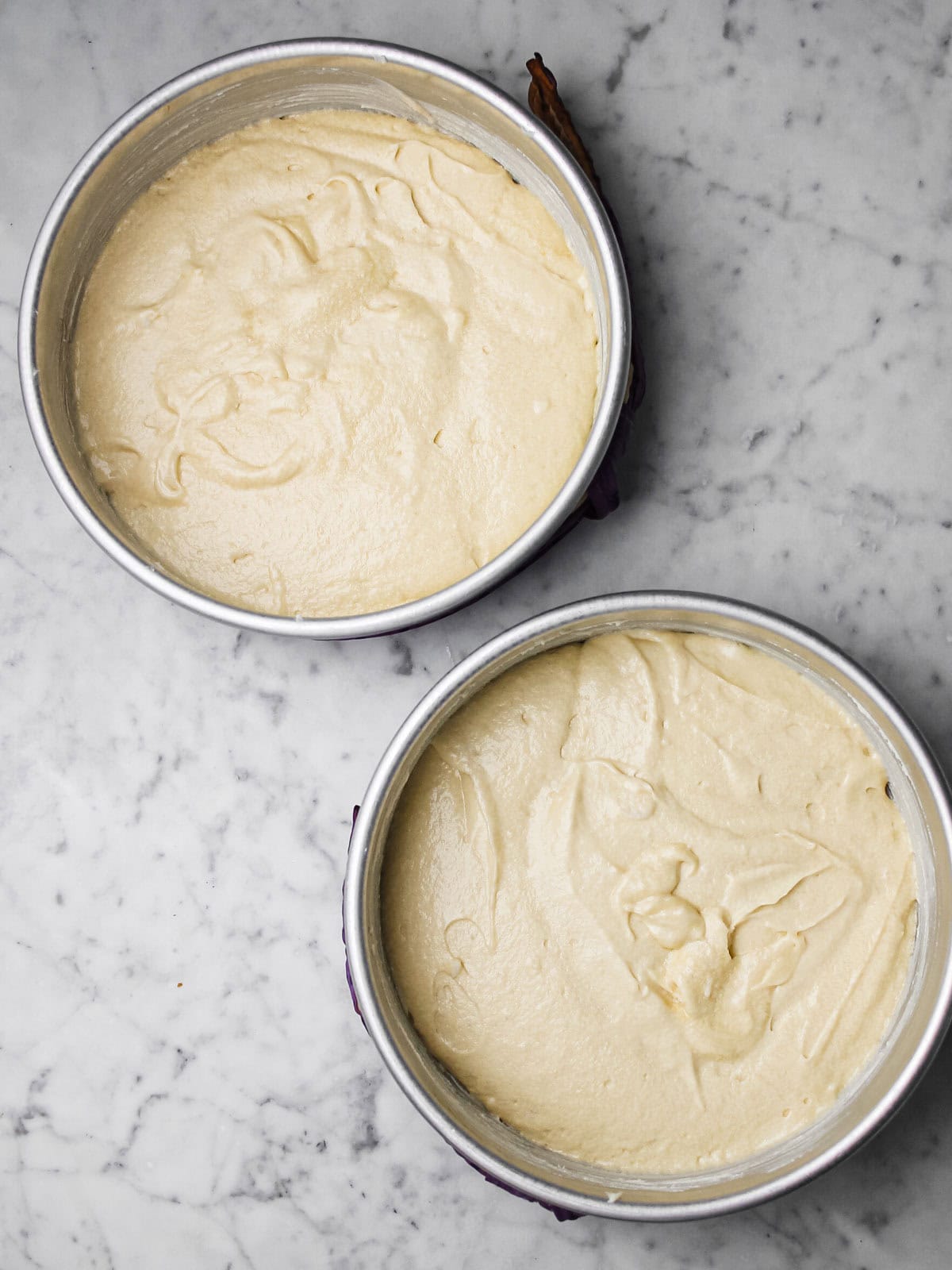 Cake pans filled with batter to make coconut mango cake.