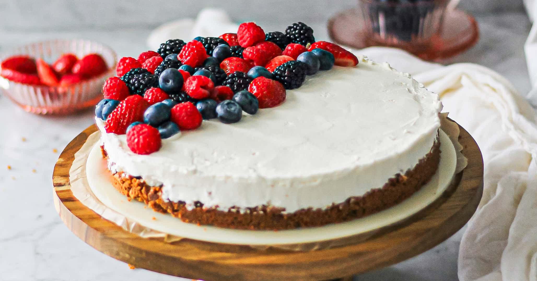 Landscape image of a no bake cheesecake with mascarpone, dressed with berries on top.