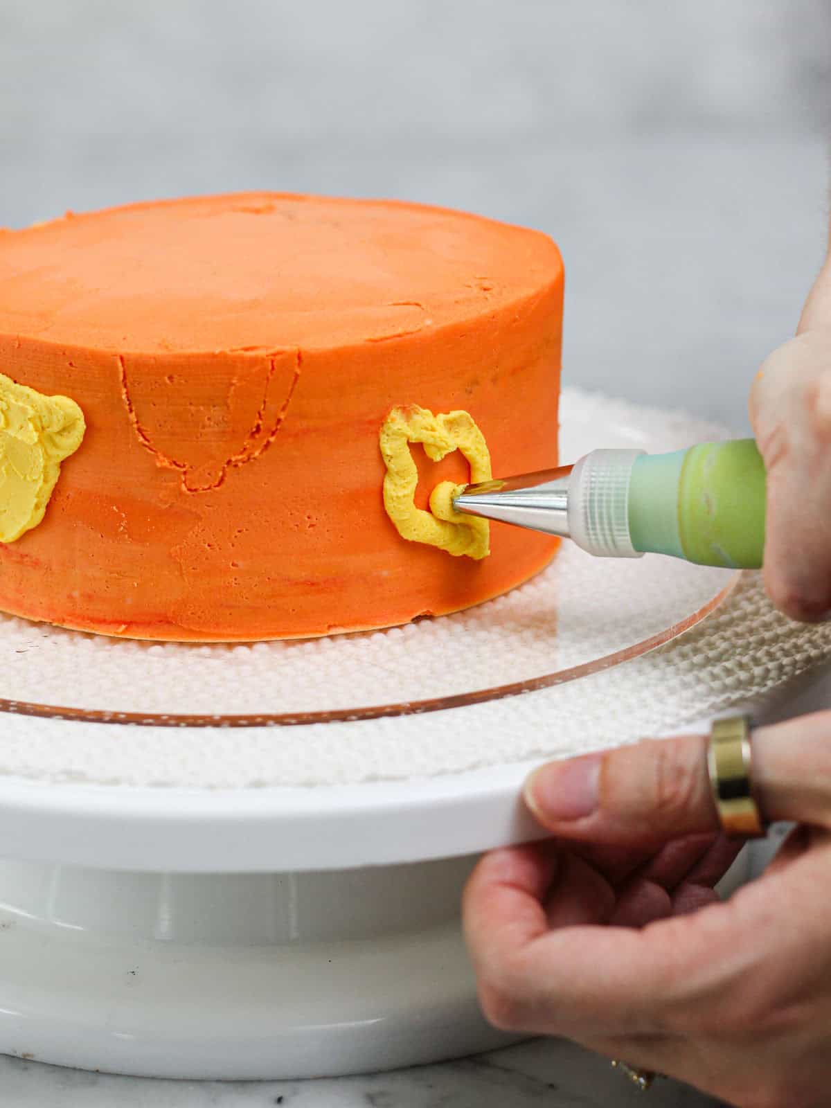 Filling in the designs of lemons for this buttercream lemon cake tutorial.