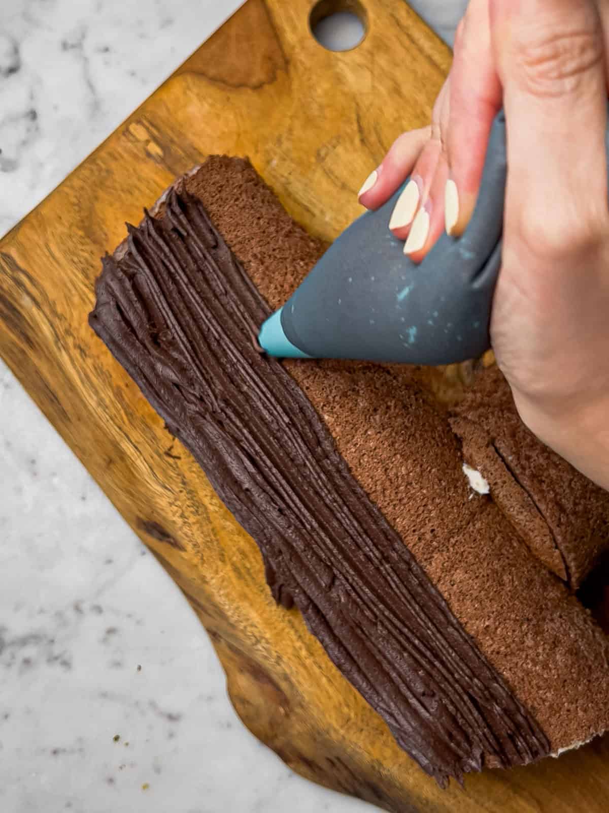 Action shot of frosting our chocolate yule log with chocolate buttercream.