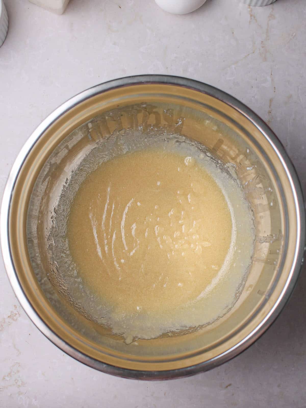 Wet ingredients for muffins in a silver mixing bowl.