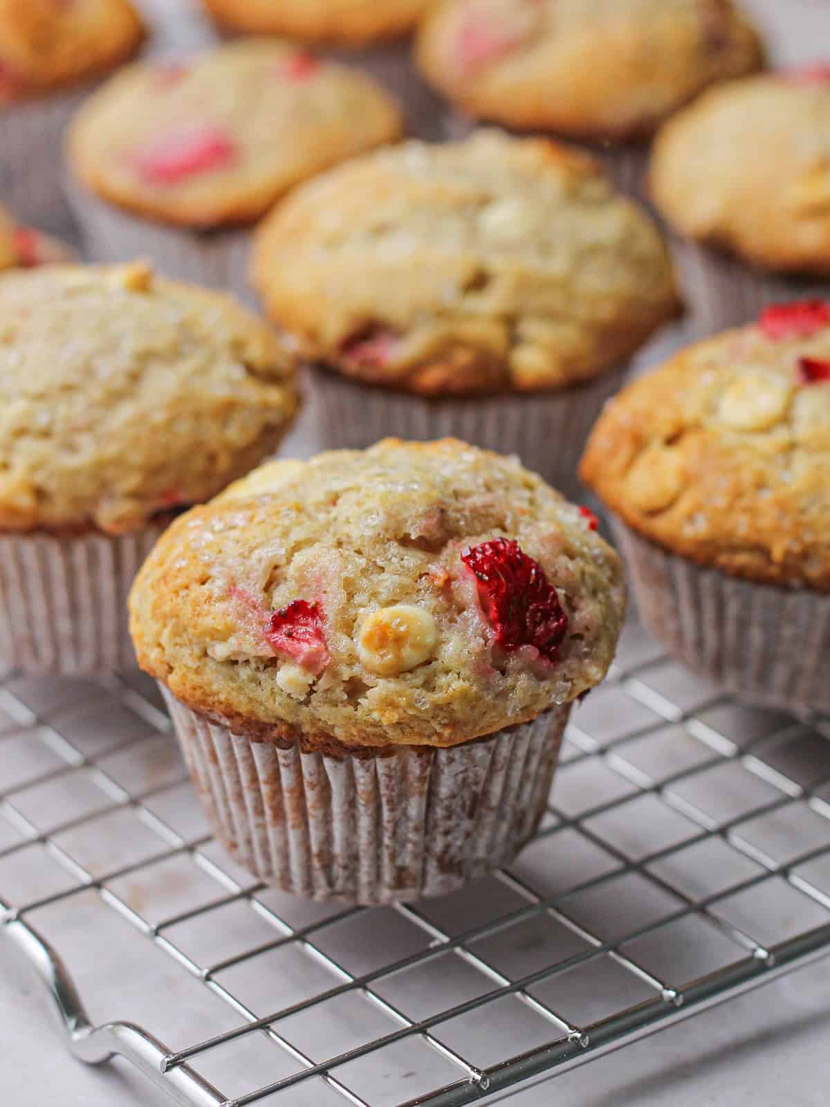 Baked strawberry white chocolate muffins, cooling on a wire rack.