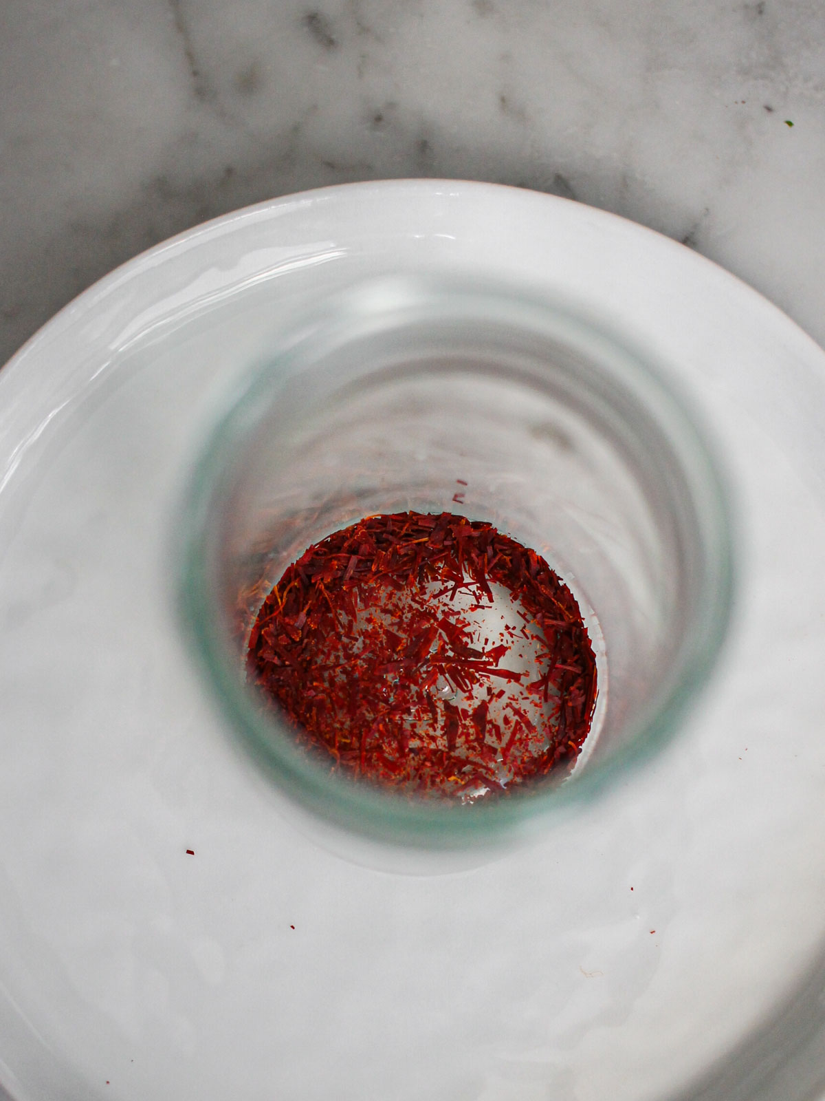 Ground saffron threads in a small clear jar.