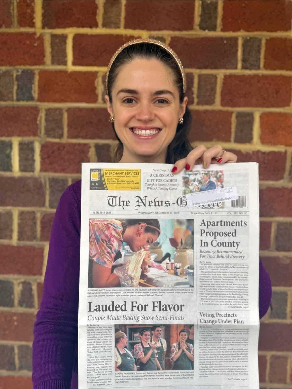 Susan holding the front page of her hometown newspaper, where she is featured for her run on Hallmark Channel's "Baked with Love."
