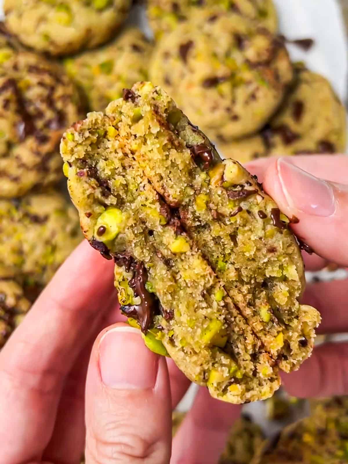 Cross-section of a pistachio dark chocolate chunk cookie, showing the chewy center.