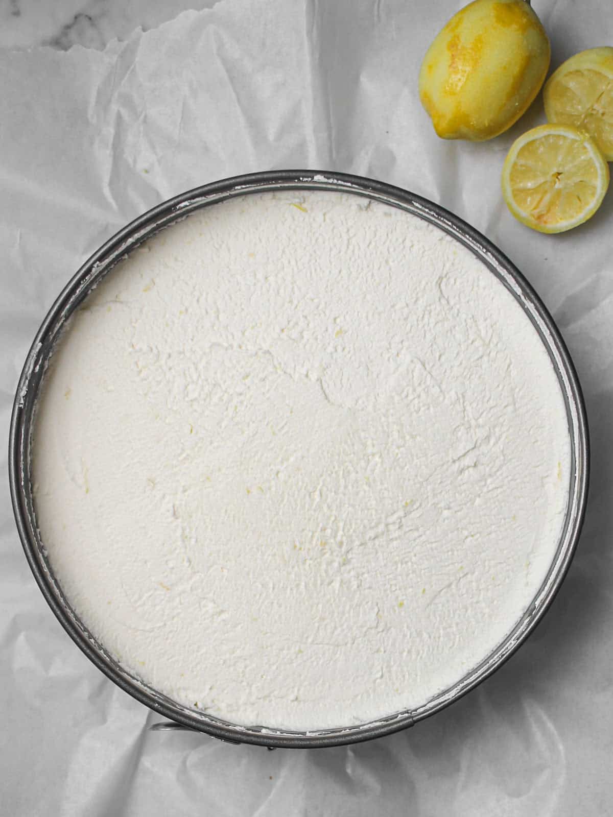 Lemon filling spread into the Biscoff crust in a springform pan.