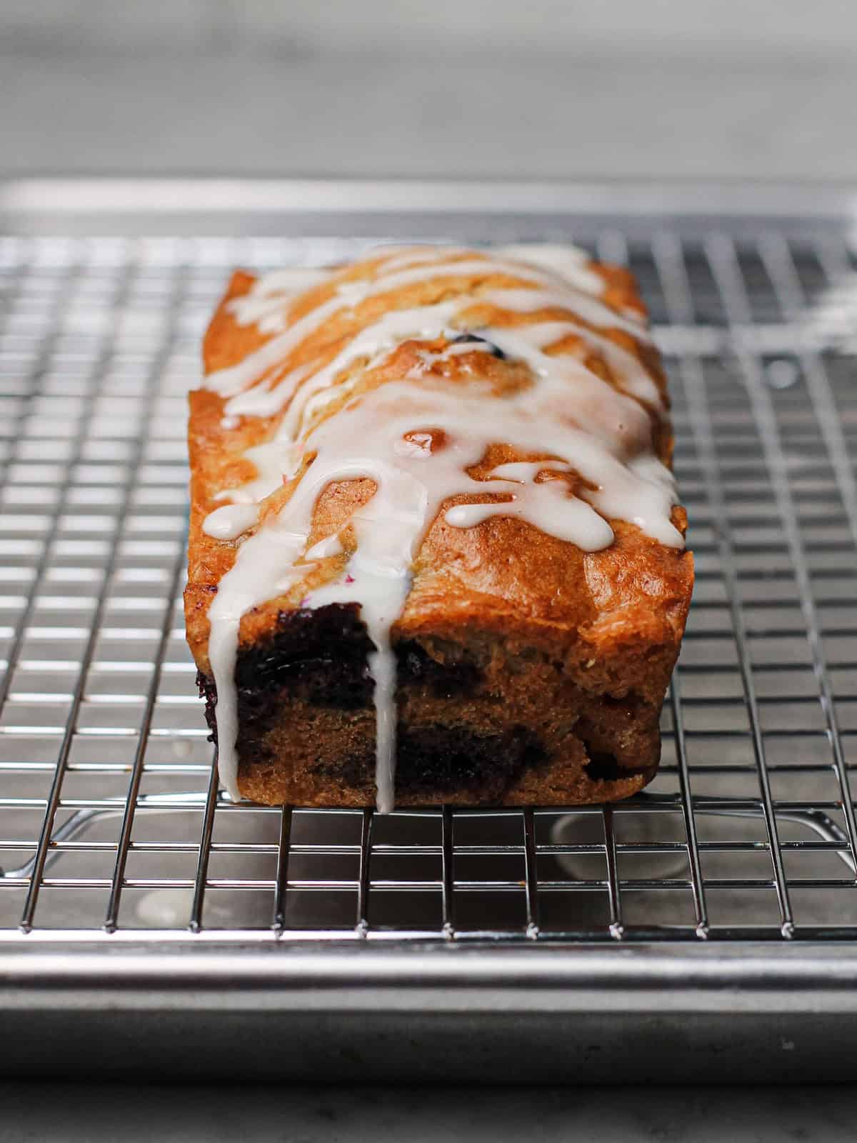 Vanilla glaze, drizzled onto a mini mixed berry loaf cake.