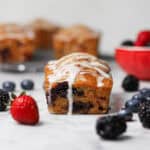 Mini mixed berry loaf cake with fresh berries and vanilla glaze.