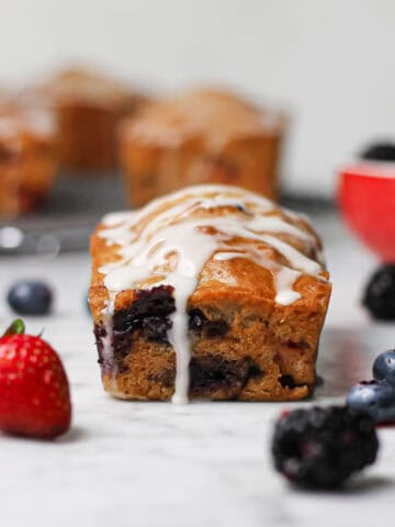 Mini mixed berry loaf cake with fresh berries and vanilla glaze.