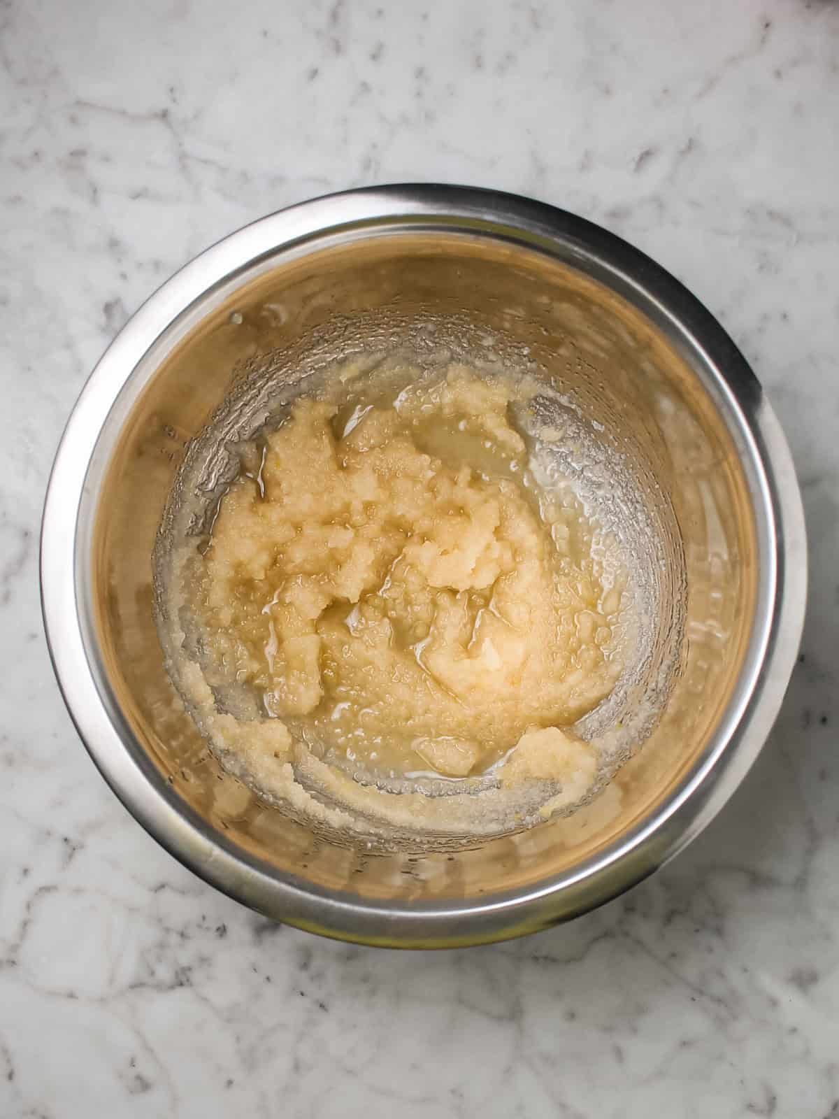 Oil, sugar, vanilla extract, and almond extract whisked together in a mixing bowl.