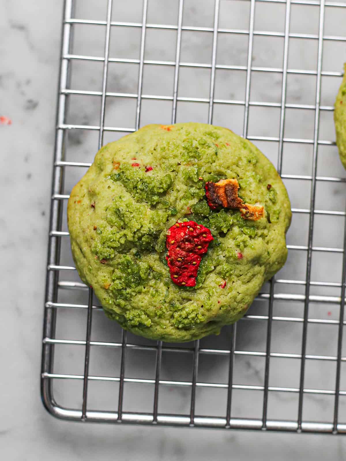 Baked strawberry basil sugar cookie cooling on a wire rack.