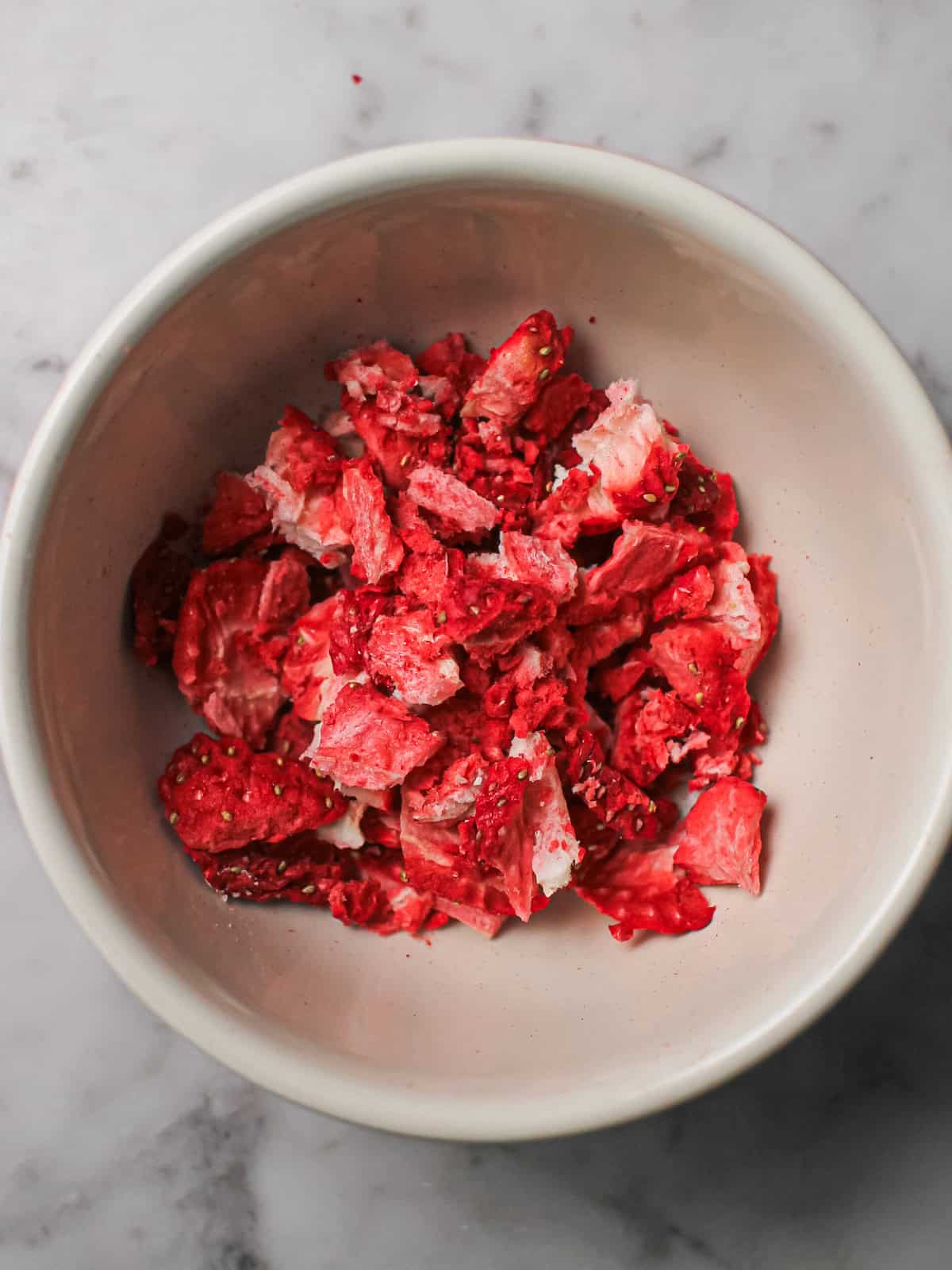 Crushed freeze-dried strawberry pieces in a small bowl.