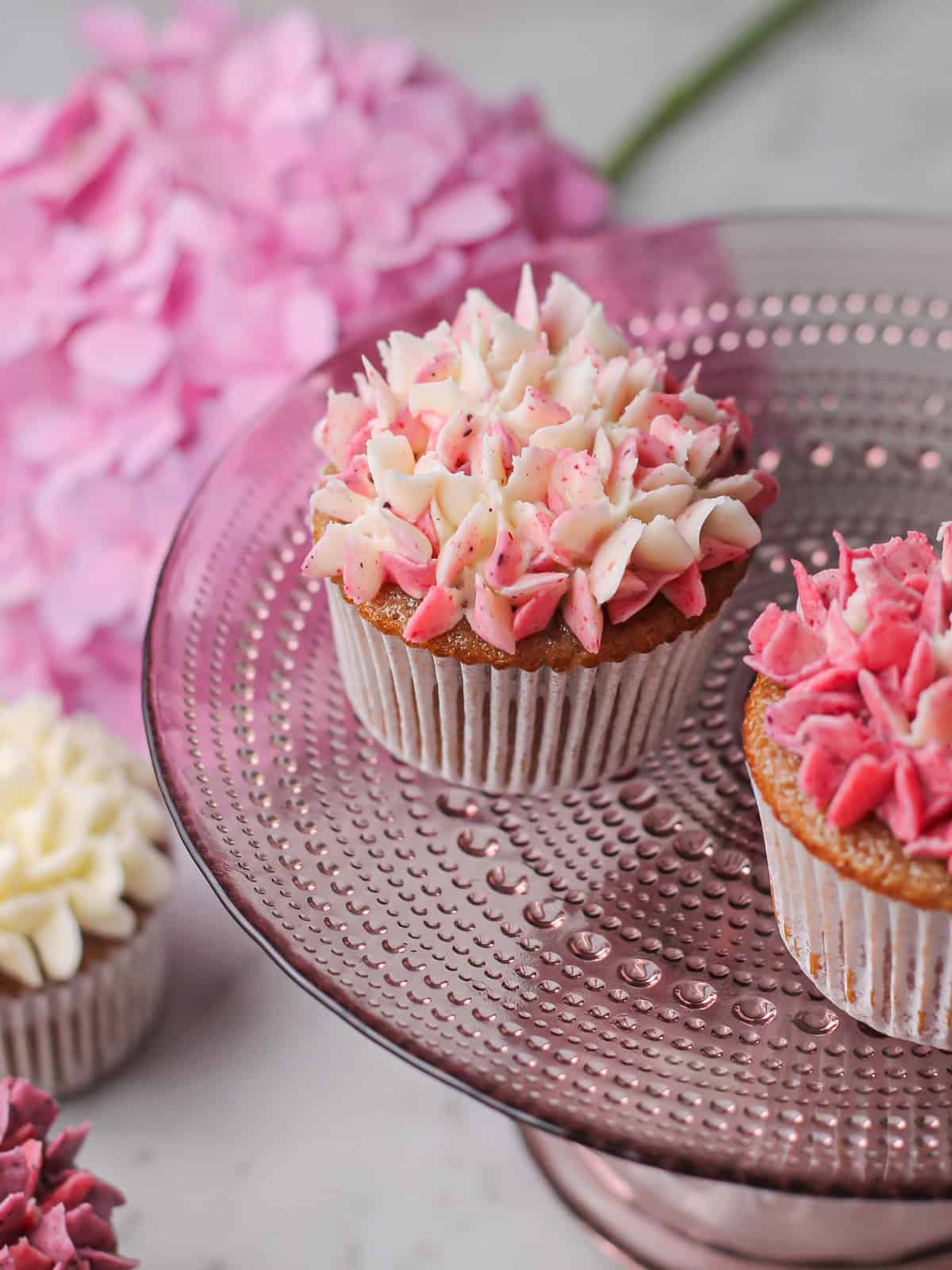 Hydrangea cupcakes on a pink cake stand.