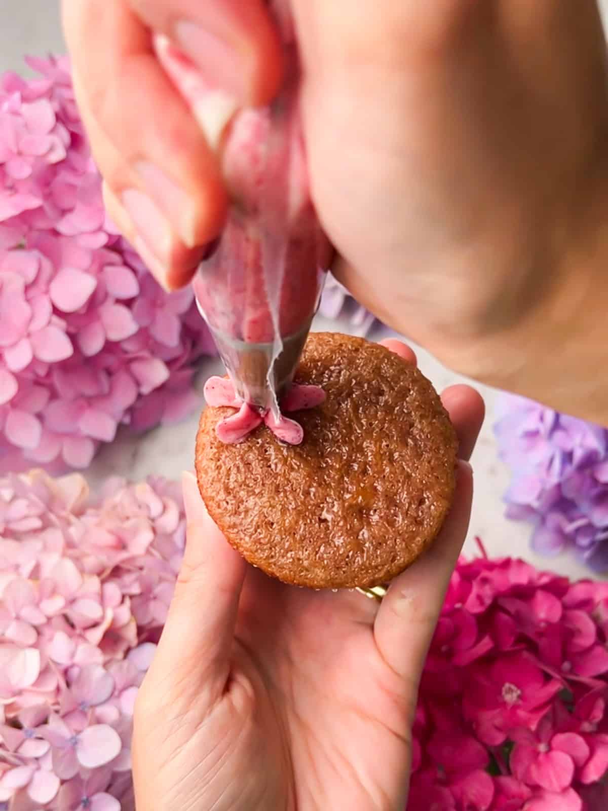 Piping a buttercream hydrangea bloom directly onto a cupcake.