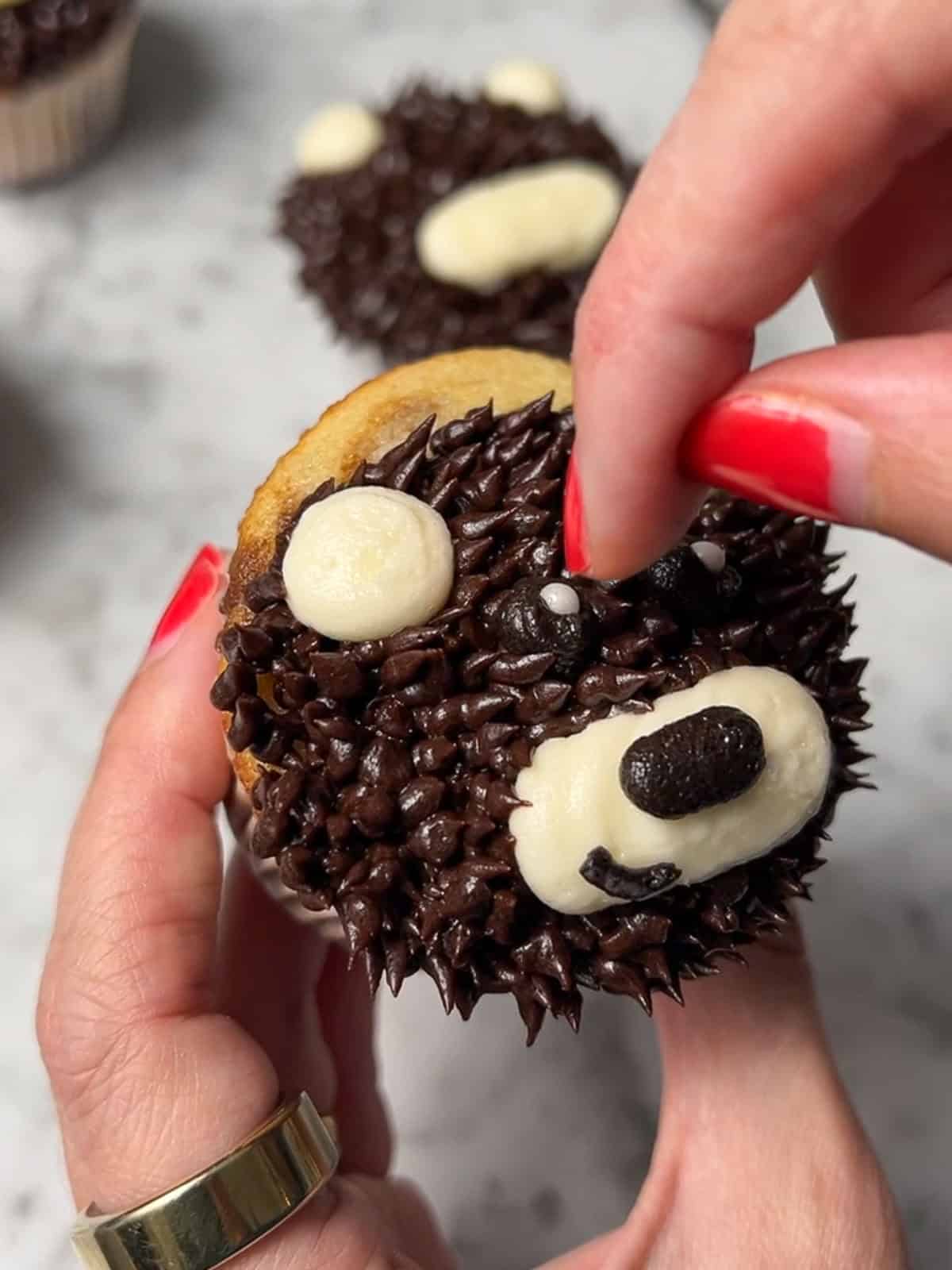 A finished brown teddy bear cupcake with sugar pearl eye highlights.