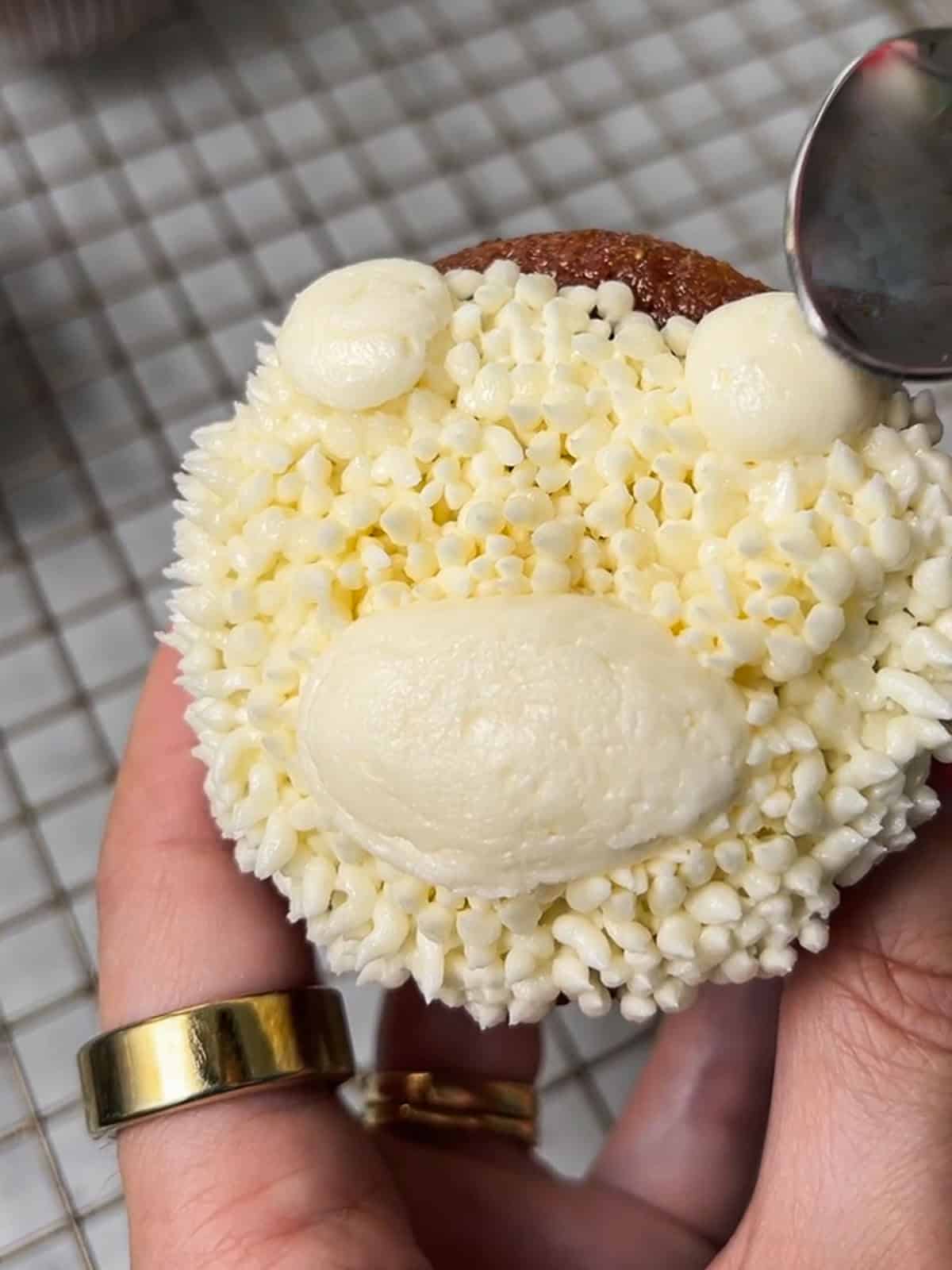 Using back of a spoon to round out rough edges on a teddy bear cupcake.