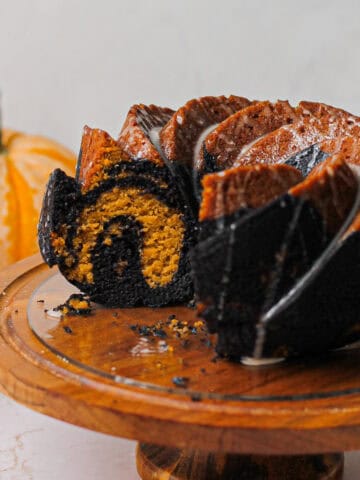 Hero image of the pumpkin bundt cake, with a portion cut to reveal the marbling.